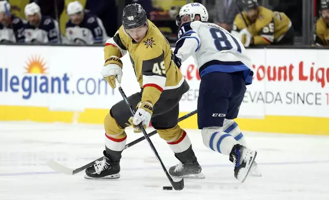 Vegas Golden Knights center Ivan Barbashev (49) skates past Winnipeg Jets left wing Kyle Connor (81) during the first period of an NHL hockey game Friday, Nov. 29, 2024, in Las Vegas. (AP Photo/Ian Maule)