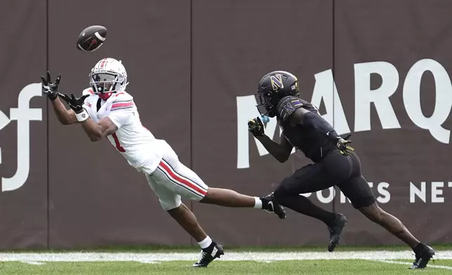 Ohio State wide receiver Carnell Tate State lays out for a touchdown pass as Northwestern defensive back Josh Fussell defends during the first half of an NCAA college football game at Wrigley Field on Saturday, Nov. 16, 2024, in Chicago. (AP Photo/Charles Rex Arbogast)