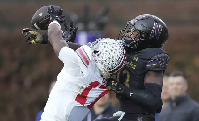 Northwestern defensive back Josh Fussell (13) breaks up a pass intended for Ohio State wide receiver Carnell Tate during the second half of an NCAA college football game at Wrigley Field on Saturday, Nov. 16, 2024, in Chicago. (AP Photo/Charles Rex Arbogast)