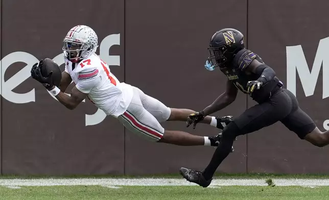 Ohio State wide receiver Carnell Tate State lays out for a touchdown pass as Northwestern defensive back Josh Fussell defends during the first half of an NCAA college football game at Wrigley Field on Saturday, Nov. 16, 2024, in Chicago. (AP Photo/Charles Rex Arbogast)