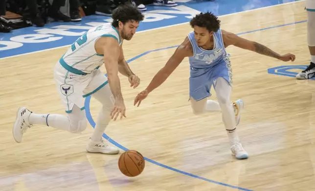 Charlotte Hornets' Vasilije Micic, left, and Cleveland Cavaliers' Craig Porter Jr., right, go for the ball during the first half of an NBA basketball game in Cleveland, Sunday, Nov 17, 2024. (AP Photo/Phil Long)