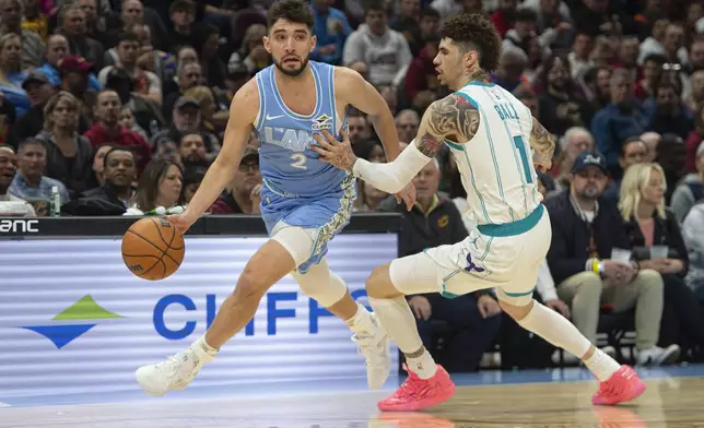 Cleveland Cavaliers' Ty Jerome (2) drives around Charlotte Hornets' LaMelo Ball (1) during the first half of an NBA basketball game in Cleveland, Sunday, Nov 17, 2024. (AP Photo/Phil Long)