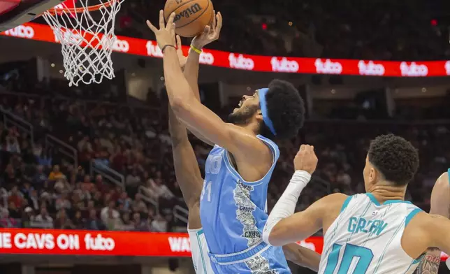 Cleveland Cavaliers' Jarrett Allen (31) drives to the basket as Charlotte Hornets' Josh Green (10) looks on during the first half of an NBA basketball game in Cleveland, Sunday, Nov 17, 2024. (AP Photo/Phil Long)