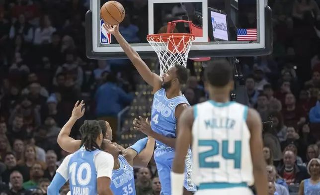 Cleveland Cavaliers' Evan Mobley (4) goes for the ball in front of teammate Isaac Okoro (35), Darius Garland (10) and Charlotte Hornets' Brandon Miller (24) during the first half of an NBA basketball game in Cleveland, Sunday, Nov 17, 2024. (AP Photo/Phil Long)