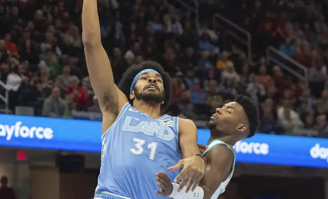 Cleveland Cavaliers' Jarrett Allen (31) drives to the basket as Charlotte Hornets' Brandon Miller, right, defends during the first half of an NBA basketball game in Cleveland, Sunday, Nov 17, 2024. (AP Photo/Phil Long)