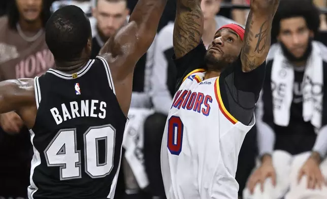 Golden State Warriors' Gary Payton II (0) goes to the basket against San Antonio Spurs' Harrison Barnes (40) during the first half of an NBA basketball game, Saturday, Nov. 23, 2024, in San Antonio. (AP Photo/Darren Abate)