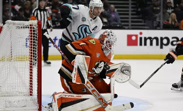 Anaheim Ducks goaltender Lukas Dostal (1) blocks a shot with Seattle Kraken center Jaden Schwartz (17) looking on during the second period of an NHL hockey game in Anaheim, Calif., Monday, Nov. 25, 2024. (AP Photo/Alex Gallardo)