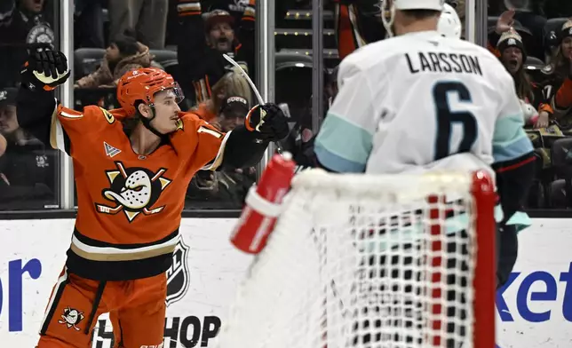 Anaheim Ducks center Trevor Zegras, left, reacts after scoring against Seattle Kraken defenseman Adam Larsson (6) during the first period of an NHL hockey game in Anaheim, Calif., Monday, Nov. 25, 2024. (AP Photo/Alex Gallardo)