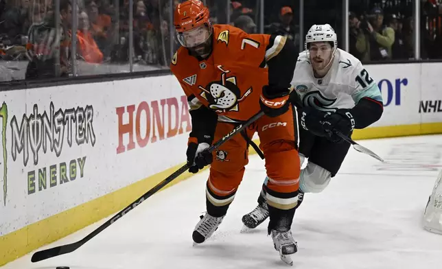 Anaheim Ducks defenseman Radko Gudas (7) passes the puck away from Seattle Kraken left wing Tye Kartye (12) during the second period of an NHL hockey game in Anaheim, Calif., Monday, Nov. 25, 2024. (AP Photo/Alex Gallardo)