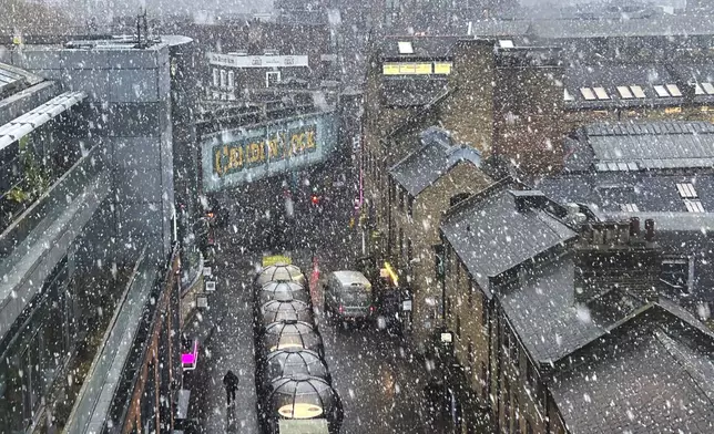 Snow falls in Camden market in London, Nov. 19, 2024. (AP Photo/Jill Lawless)