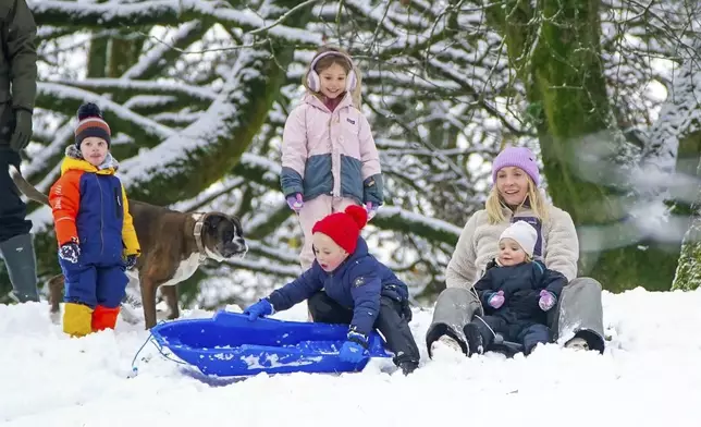 People play in the snow on the hills of Buxton, Derbyshire, Britain, Tuesday, Nov. 19, 2024. (Peter Byrne/PA via AP)