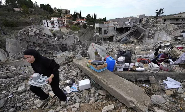 A woman collects the remains of her destroyed house after she returned to Chehabiyeh village, southern Lebanon, Thursday, Nov. 28, 2024 following a ceasefire between Israel and Hezbollah that went into effect on Wednesday.(AP Photo/Hussein Malla)