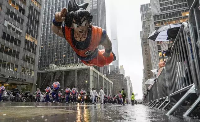 Handlers guide the Goku balloon down Sixth Avenue during the Macy's Thanksgiving Day Parade, Thursday, Nov. 28, 2024, in New York. (AP Photo/Julia Demaree Nikhinson)