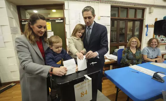 Irish Prime Minister and Fine Gael leader Simon Harris, center, accompanied by his wife Caoimhe and children Cillian and Saoirse, casts his vote at Delgany National School, County Wicklow, as voters go to the polls for the 2024 General Election in Ireland, Friday Nov. 29, 2024. (Niall Carson/PA via AP)