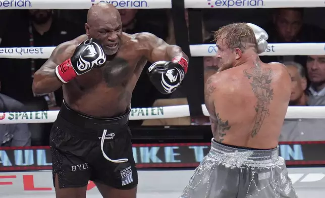 Mike Tyson, left, fights Jake Paul during their heavyweight boxing match, Friday, Nov. 15, 2024, in Arlington, Texas. (AP Photo/Julio Cortez)