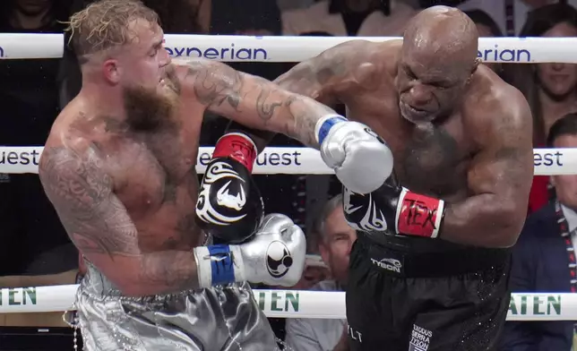 Jake Paul, left, fights Mike Tyson during their heavyweight boxing match, Friday, Nov. 15, 2024, in Arlington, Texas. (AP Photo/Julio Cortez)