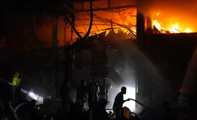 Civil defense workers extinguish a fire at the site of an Israeli airstrike in Beirut, Sunday, Nov. 17, 2024. (AP Photo/Hassan Ammar)