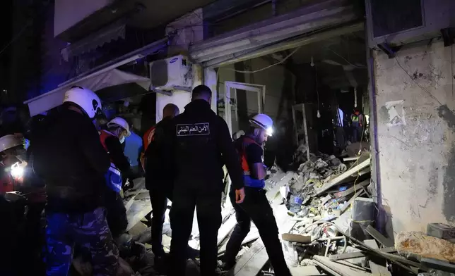 Rescue workers and policemen search for victims at the site of an Israeli airstrike in Beirut, Lebanon, Monday, Nov. 18, 2024. (AP Photo/Hussein Malla)