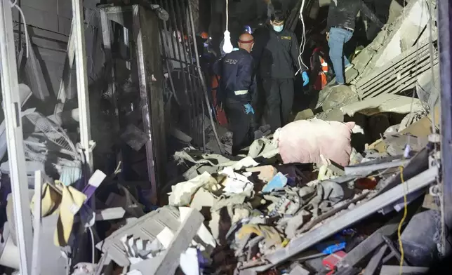 Rescue workers and residents search for victims at the site of an Israeli airstrike in Beirut, Lebanon, Monday, Nov. 18, 2024. (AP Photo/Hussein Malla)