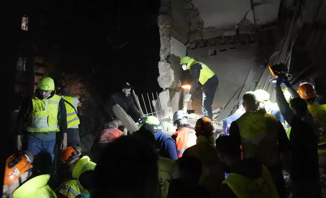 Rescue workers search for victims at the site of an Israeli airstrike in Beirut, Lebanon, Monday, Nov. 18, 2024. (AP Photo/Hussein Malla)