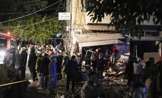 Residents and rescuers gather at the site of an Israeli airstrike in Beirut, Lebanon, Monday, Nov. 18, 2024. (AP Photo/Bilal Hussein)