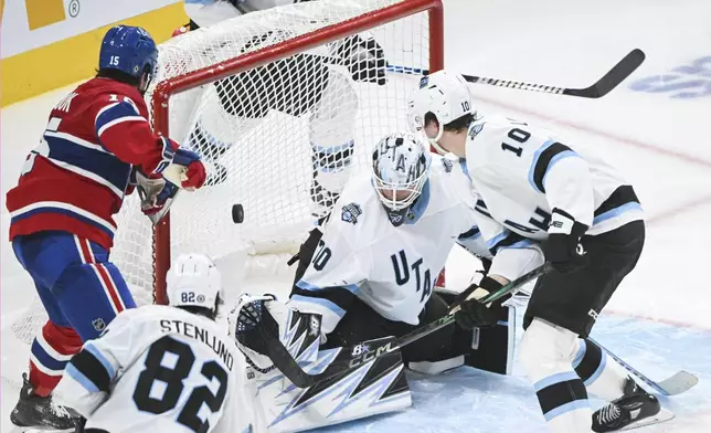 Montreal Canadiens' Alex Newhook (15) scores against Utah Hockey Club goaltender Karel Vejmelka as Utah's Maveric Lamoureux (10) and Kevin Stenlund (82) defend during third period NHL hockey action in Montreal, Tuesday, Nov. 26, 2024. (Graham Hughes/The Canadian Press via AP)