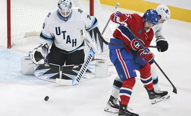 Montreal Canadiens' Alex Newhook looks for the puck as he moves in on Utah Hockey Club goaltender Karel Vejmelka during the second period of an NHL hockey game in Montreal, Tuesday, Nov. 26, 2024. (Graham Hughes/The Canadian Press via AP)