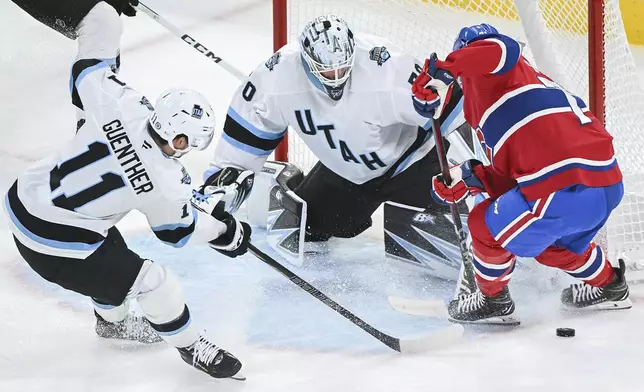 Montreal Canadiens' Jake Evans moves in on Utah Hockey Club goaltender Karel Vejmelka as Utah's Dylan Guenther (11) defends during the second period of an NHL hockey game in Montreal, Tuesday, Nov. 26, 2024. (Graham Hughes/The Canadian Press via AP)