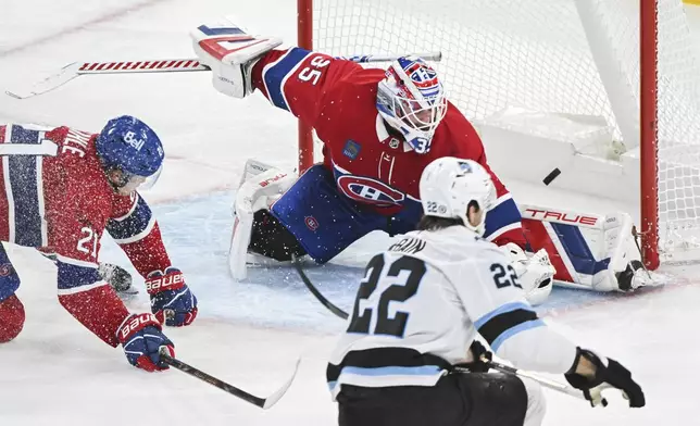 Utah Hockey Club's Jack McBain (22) scores against Montreal Canadiens goaltender Sam Montembeault as Canadiens' Kaiden Guhle (21) defends during third period NHL hockey action in Montreal, Tuesday, Nov. 26, 2024. (Graham Hughes/The Canadian Press via AP)