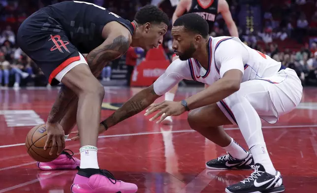 Houston Rockets forward Jabari Smith Jr., left, looks for a way around as Los Angeles Clippers guard Norman Powell, right, reaches in during the first half of an Emirates NBA Cup basketball game Friday, Nov. 15, 2024, in Houston. (AP Photo/Michael Wyke)