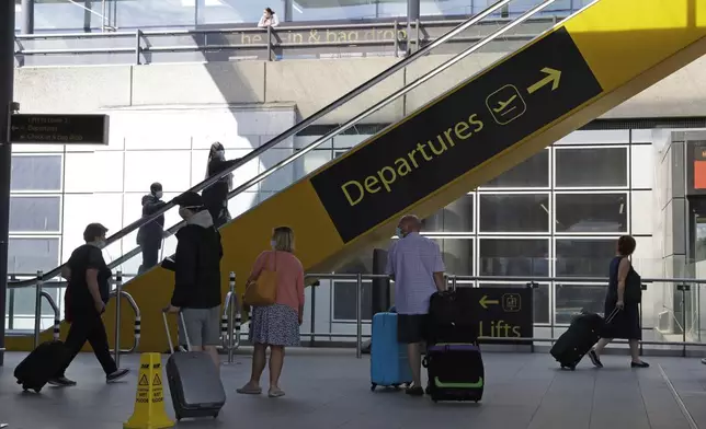 FILE - Passengers head to departures, at the Gatwick Airport near Crawley, south of London, on July 22, 2020. (AP Photo/Matt Dunham, File)