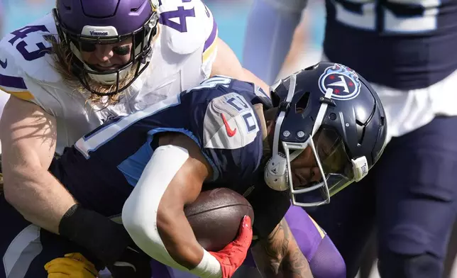 Tennessee Titans running back Tony Pollard (20) is tackled by Minnesota Vikings linebacker Andrew Van Ginkel (43) during the first half of an NFL football game, Sunday, Nov. 17, 2024, in Nashville, Tenn. (AP Photo/George Walker IV)