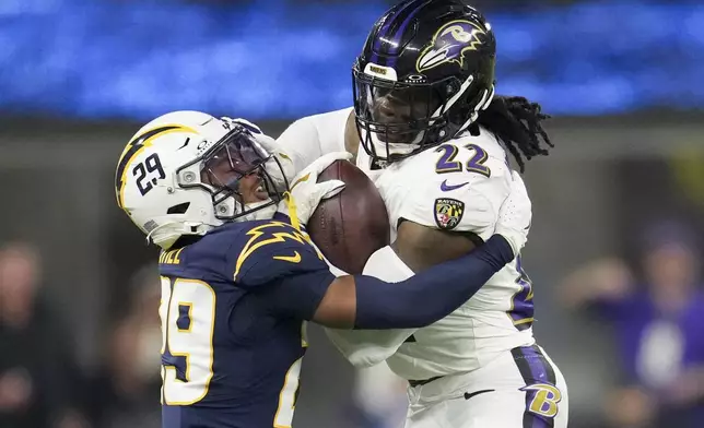 Baltimore Ravens running back Derrick Henry (22) is tackled by Los Angeles Chargers cornerback Tarheeb Still (29) during the second half of an NFL football game Monday, Nov. 25, 2024, in Inglewood, Calif. (AP Photo/Eric Thayer)