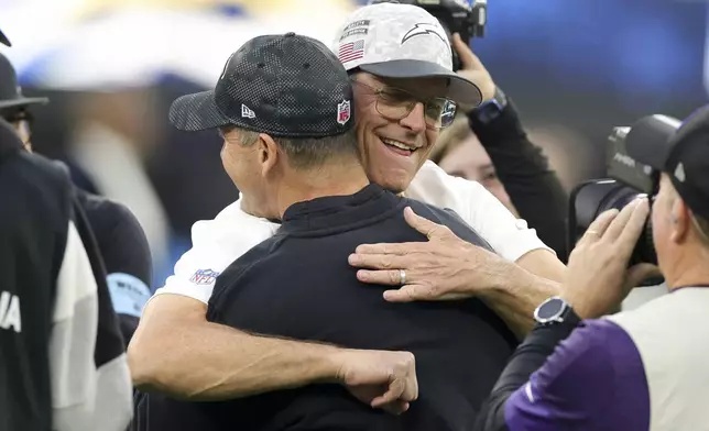 Los Angeles Chargers head coach Jim Harbaugh, right, hugs his brother Baltimore Ravens Head Coach John Harbaugh before an NFL football game Monday, Nov. 25, 2024, in Inglewood, Calif. (AP Photo/Ryan Sun)