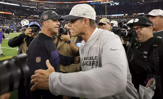 Baltimore Ravens Head Coach John Harbaugh, left, hugs Los Angeles Chargers head coach Jim Harbaugh after an NFL football game Monday, Nov. 25, 2024, in Inglewood, Calif. (AP Photo/Ryan Sun)