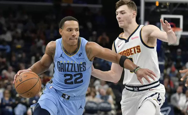 Memphis Grizzlies guard Desmond Bane (22) handles the ball against Denver Nuggets guard Christian Braun (0) in the first half of an Emirates NBA Cup basketball game Tuesday, Nov. 19, 2024, in Memphis, Tenn. (AP Photo/Brandon Dill)