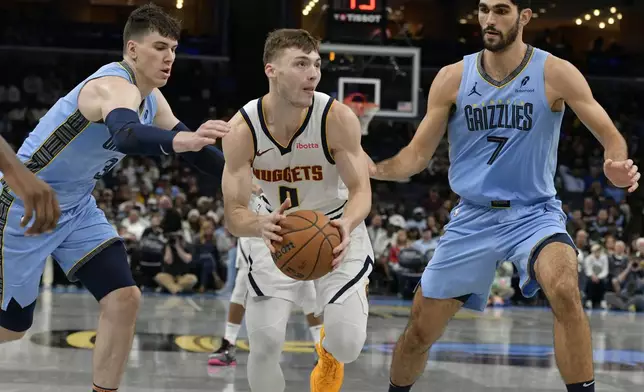 Denver Nuggets guard Christian Braun (0) handles the ball between Memphis Grizzlies forwards Jake LaRavia (3) and Santi Aldama (7) in the second half of an Emirates NBA Cup basketball game Tuesday, Nov. 19, 2024, in Memphis, Tenn. (AP Photo/Brandon Dill)