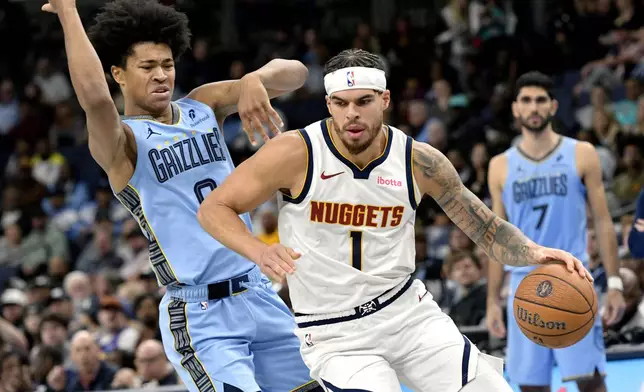 Denver Nuggets forward Michael Porter Jr. (1) handles the ball ahead of Memphis Grizzlies forward Jaylen Wells (0) in the second half of an Emirates NBA Cup basketball game Tuesday, Nov. 19, 2024, in Memphis, Tenn. (AP Photo/Brandon Dill)