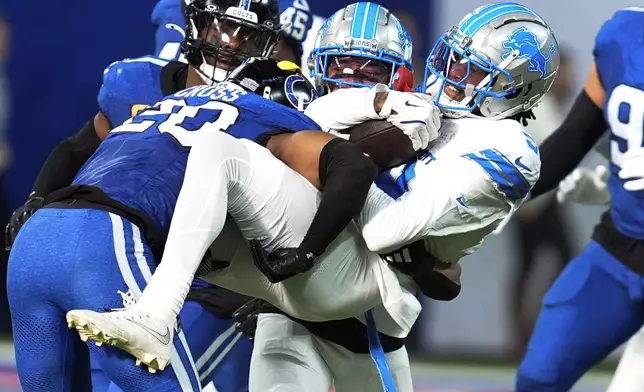 Detroit Lions wide receiver Jameson Williams (9) is tackled by Indianapolis Colts safety Nick Cross (20) during the second half of an NFL football game, Sunday, Nov. 24, 2024, in Indianapolis. (AP Photo/Michael Conroy)