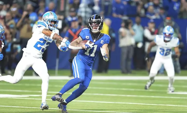 Indianapolis Colts wide receiver Michael Pittman Jr. (11) is chased by Detroit Lions cornerback Carlton Davis III (23) during the first half of an NFL football game, Sunday, Nov. 24, 2024, in Indianapolis. (AP Photo/Michael Conroy)