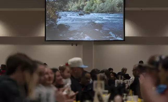 An image of land recently purchased by the Confederated Tribes of Siletz Indians is displayed on a screen during a lunch for tribal members and guests before a powwow at Chinook Winds Casino Resort, Saturday, Nov. 16, 2024, in Lincoln City, Ore. (AP Photo/Jenny Kane)