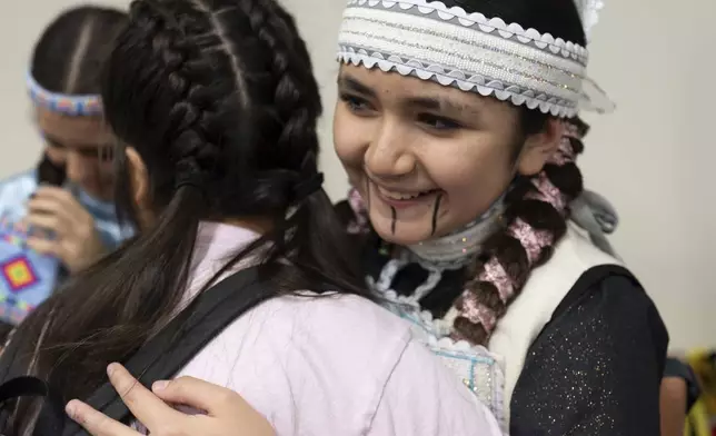 Sun-taa-chu Butler, right, hugs a friend as they get ready for a powwow at Chinook Winds Casino Resort, Saturday, Nov. 16, 2024, in Lincoln City, Ore. (AP Photo/Jenny Kane)