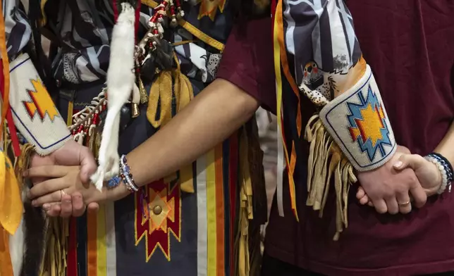 People hold hands during a dance at a powwow at Chinook Winds Casino Resort, Saturday, Nov. 16, 2024, in Lincoln City, Ore. (AP Photo/Jenny Kane)