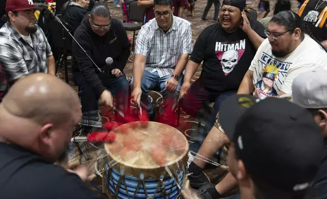 Members of the Warrior Society drum group, clockwise from bottom left, Taylor Hawk, Jimmy Williams, J.J. Jackson, Lawney Havranek, George Clements, Henry Rondeau, Plummie Wright, and Ron Butler, perform during a powwow at Chinook Winds Casino Resort, Saturday, Nov. 16, 2024, in Lincoln City, Ore. (AP Photo/Jenny Kane)