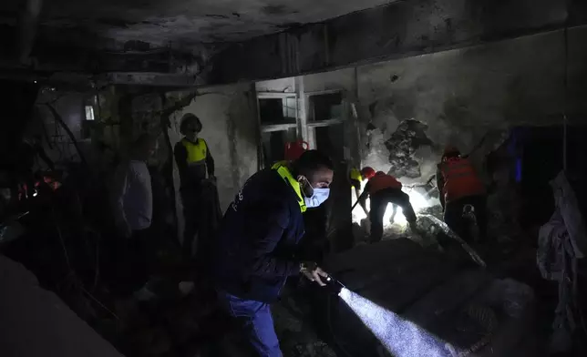 Rescue workers search for victims at the site of an Israeli airstrike in Beirut, Lebanon, Monday, Nov. 18, 2024. (AP Photo/Hussein Malla)