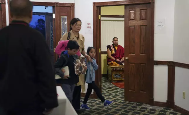 U.S.-born Buddhist lama, Jalue Dorje, right, waits in a private room before making an entrance at his 18th birthday and enthronement ceremony that hundreds attended in Isanti, Minn., on Saturday, Nov. 9, 2024. (AP Photo/Jessie Wardarski)