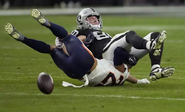 Denver Broncos safety Brandon Jones breaks up a pass intended for Las Vegas Raiders tight end Brock Bowers, right, during the second half of an NFL football game, Sunday, Nov. 24, 2024, in Las Vegas. (AP Photo/John Locher)