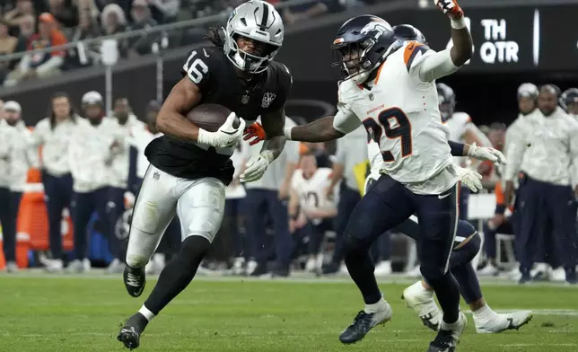 Las Vegas Raiders wide receiver Jakobi Meyers (16) runs after the catch as Denver Broncos cornerback Ja'Quan McMillian (29) defends during the second half of an NFL football game, Sunday, Nov. 24, 2024, in Las Vegas. (AP Photo/Rick Scuteri)