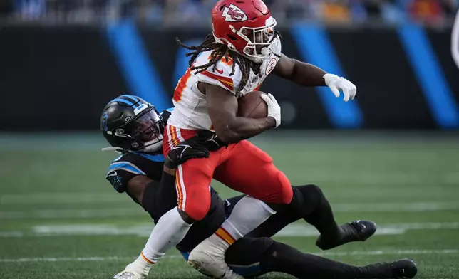 Carolina Panthers linebacker Trevin Wallace (56) tackles Kansas City Chiefs running back Kareem Hunt (29) during the second half of an NFL football game, Sunday, Nov. 24, 2024, in Charlotte, N.C. (AP Photo/Rusty Jones)