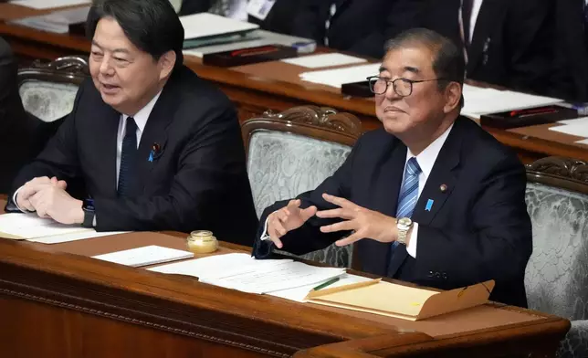 Japanese Prime Minister Shigeru Ishiba, right, gestures before delivering his policy speech at the extraordinary session of parliament's lower house Friday, Nov. 29, 2024, in Tokyo. (AP Photo/Eugene Hoshiko)